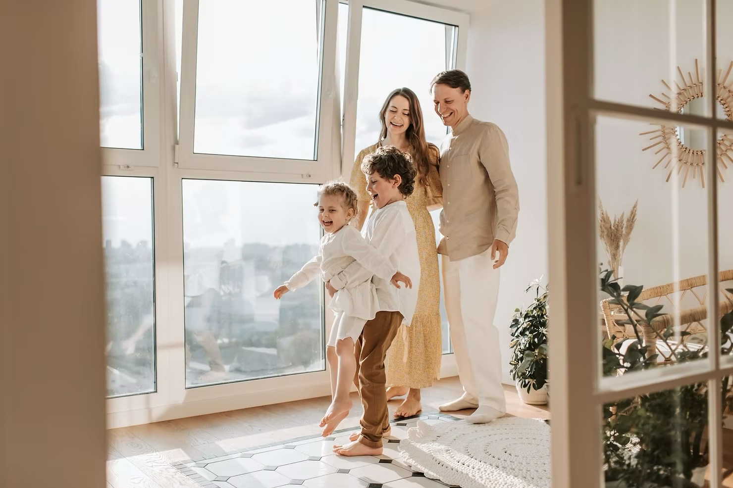 family hugging in living room in front of windows